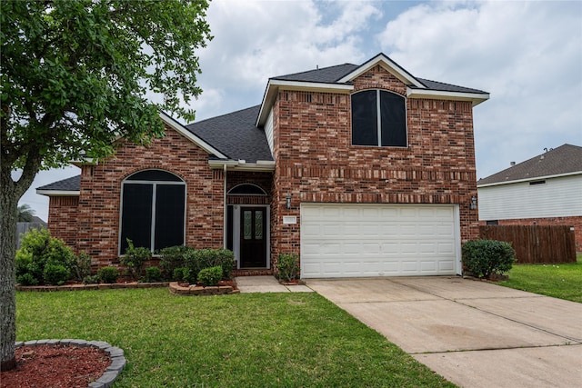 view of front of house featuring a garage, a front yard, roof with shingles, and brick siding