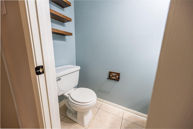 bathroom featuring toilet, baseboards, and tile patterned flooring