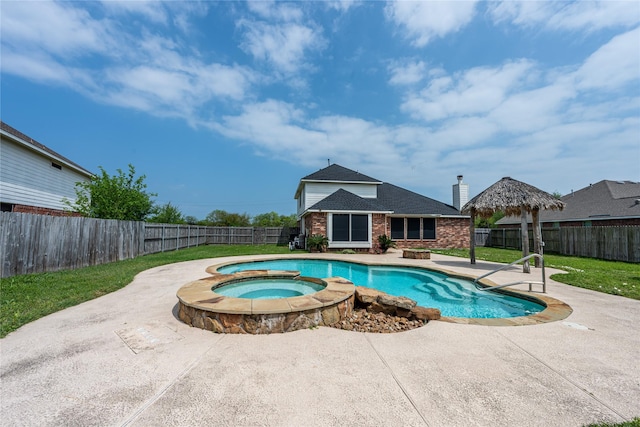 view of pool with a patio area, a fenced backyard, a pool with connected hot tub, and a lawn