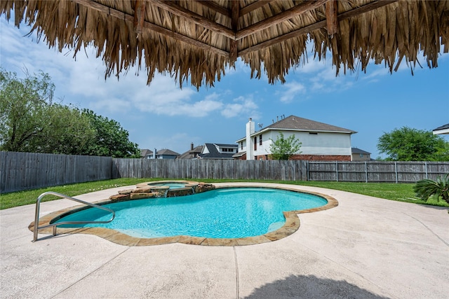 view of swimming pool featuring a patio, a pool with connected hot tub, a fenced backyard, and a yard