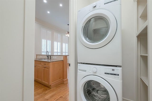 1804 Haddon St, Houston, TX 77019 - washroom with stacked washer / dryer, light wood-style flooring, and recessed lighting