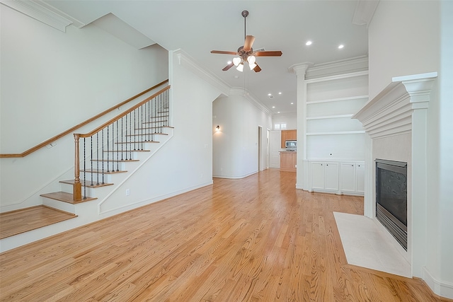 1804 Haddon St, Houston, TX 77019 - unfurnished living room with a fireplace with flush hearth, a ceiling fan, stairway, light wood-type flooring, and built in shelves