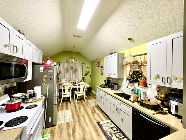 kitchen with vaulted ceiling, stainless steel microwave, black dishwasher, electric stove, and visible vents