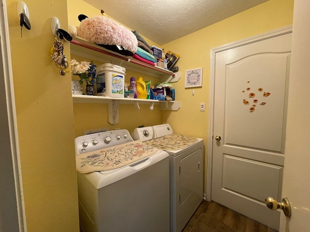 laundry room featuring washing machine and clothes dryer, a textured ceiling, laundry area, and dark wood finished floors