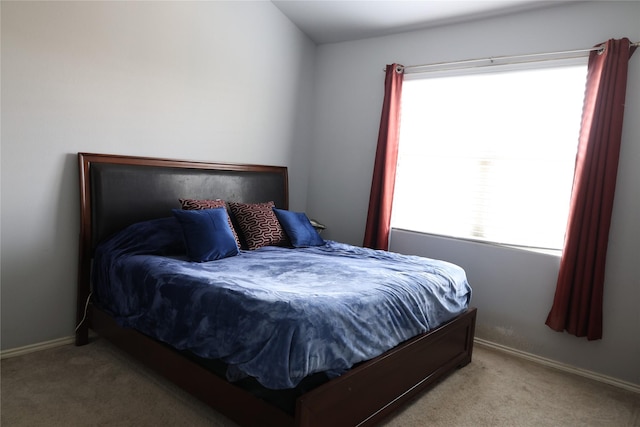 bedroom with light carpet, multiple windows, and baseboards
