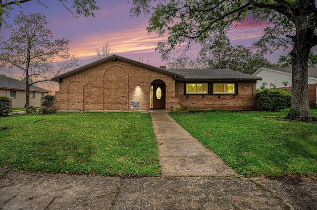 view of front of property featuring brick siding and a front lawn