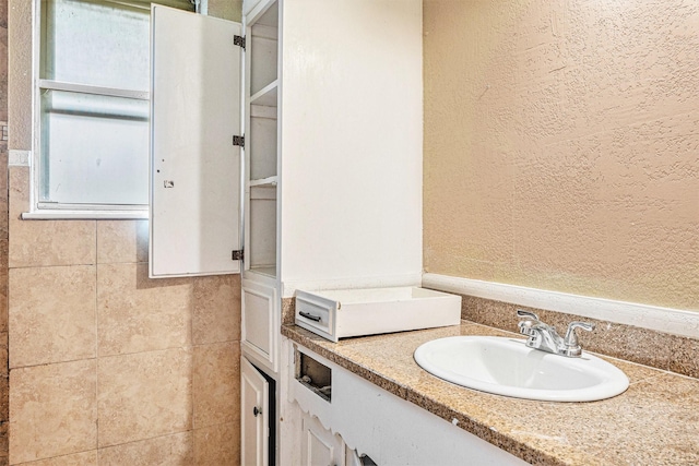 bathroom with vanity and a textured wall