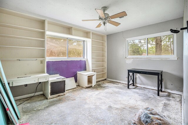 interior space with baseboards and ceiling fan