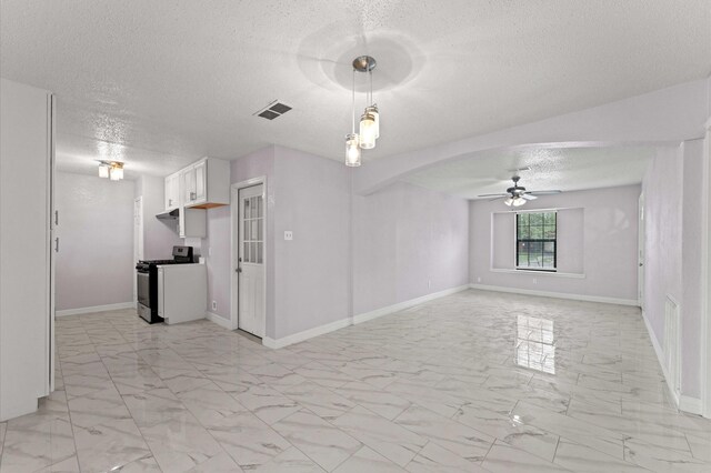 empty room with marble finish floor, a textured ceiling, visible vents, and a ceiling fan
