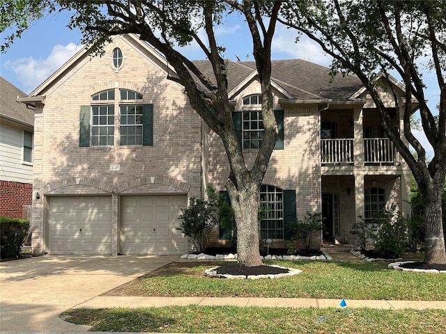 view of front of property featuring a balcony, concrete driveway, a garage, and brick siding