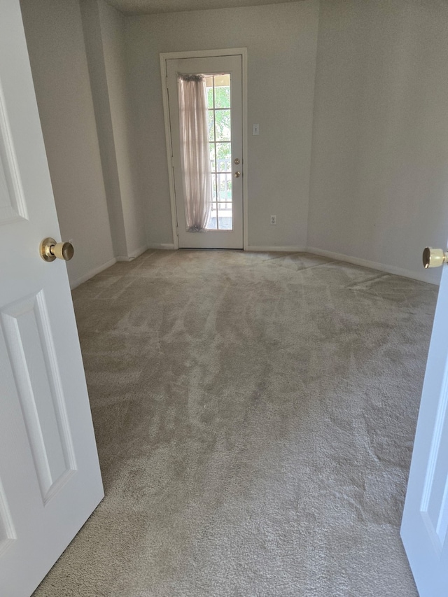 empty room with baseboards and carpet
