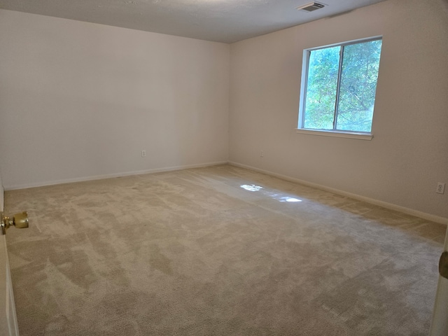 carpeted spare room with baseboards and visible vents