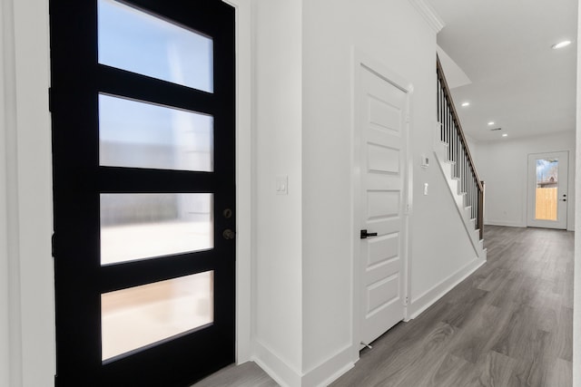 foyer with recessed lighting, baseboards, stairs, and wood finished floors