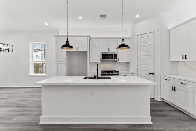 kitchen featuring crown molding, tasteful backsplash, a sink, and stainless steel microwave