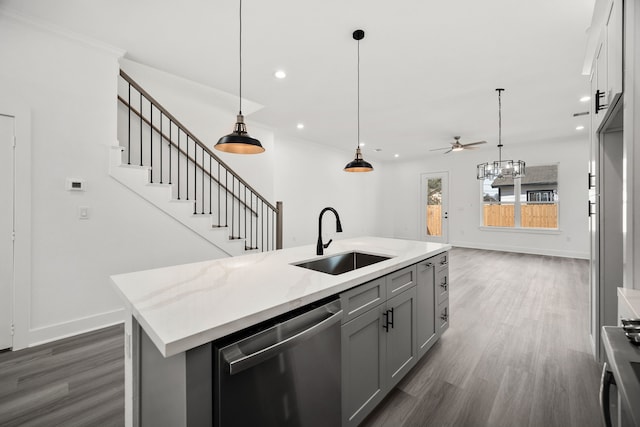 kitchen with a ceiling fan, dark wood-type flooring, a sink, gray cabinetry, and stainless steel dishwasher
