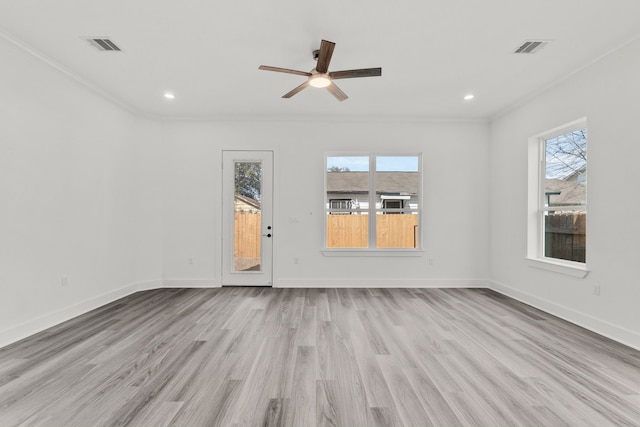 unfurnished living room with wood finished floors, ornamental molding, a healthy amount of sunlight, and visible vents