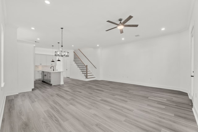unfurnished living room featuring stairs, a sink, a ceiling fan, light wood finished floors, and recessed lighting
