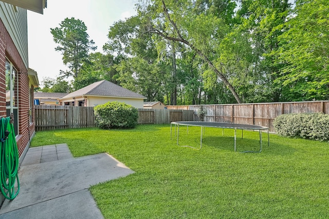 view of yard with a trampoline, a patio area, and a fenced backyard