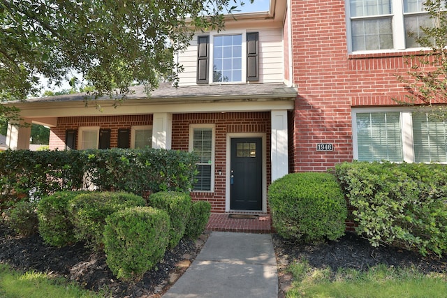 property entrance featuring brick siding