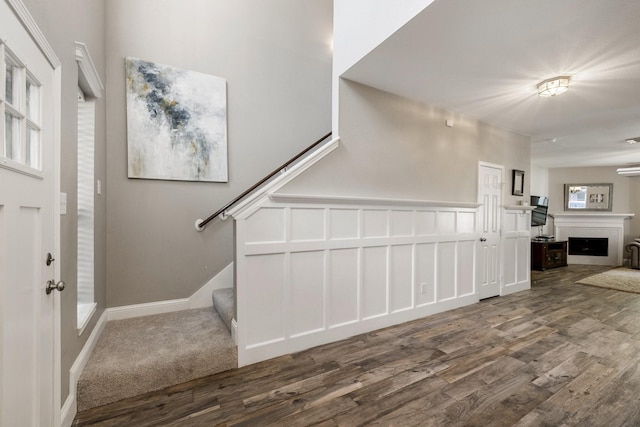 entryway featuring a fireplace, wood finished floors, and stairway