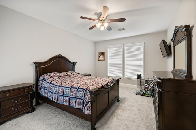 bedroom with visible vents, a ceiling fan, baseboards, and light carpet