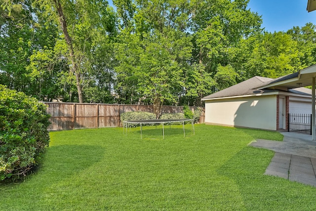view of yard with a fenced backyard and a trampoline