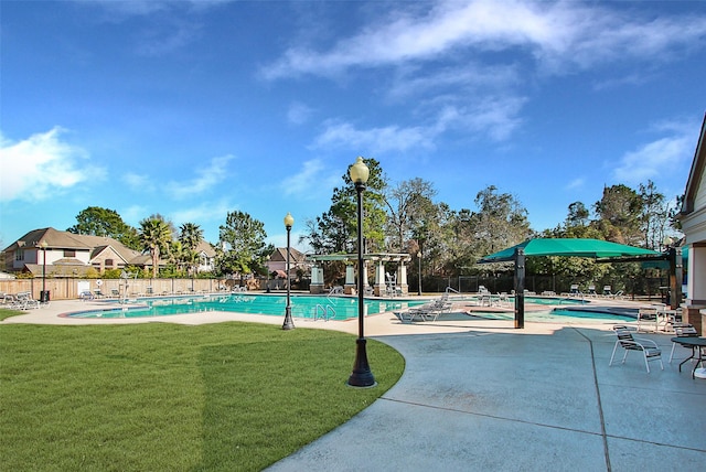 pool featuring a patio area, fence, and a yard