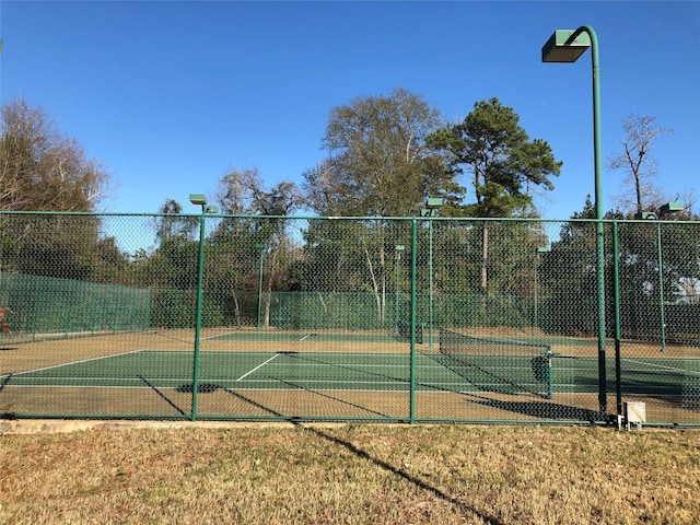 view of tennis court featuring fence