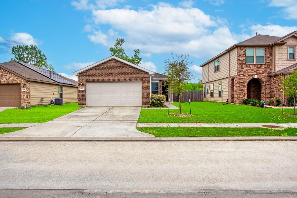 11602 Bodark Valley Ln, Houston, TX 77038 - view of front of house with concrete driveway, fence, a front lawn, brick siding, and central AC