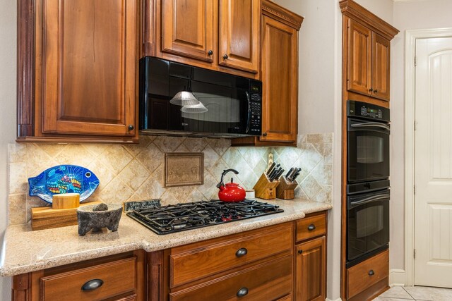 8408 Grand Lake Estates Dr, Montgomery, TX 77316 - kitchen with brown cabinets, light stone countertops, black appliances, and decorative backsplash