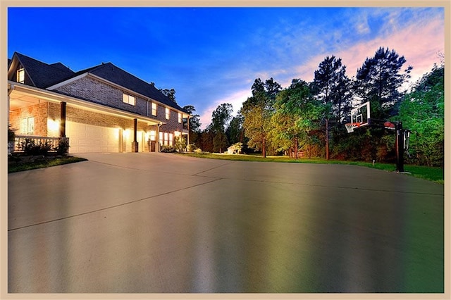 8408 Grand Lake Estates Dr, Montgomery, TX 77316 - property exterior at dusk featuring driveway, an attached garage, and brick siding