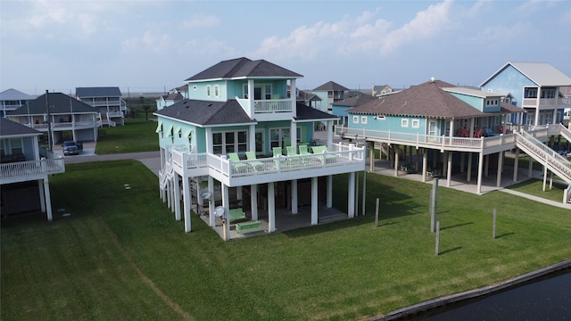 3212 Sea Castle Dr, Crystal Beach, TX 77650 - back of house with a balcony, a residential view, a shingled roof, a patio, and a lawn