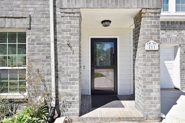 entrance to property featuring brick siding