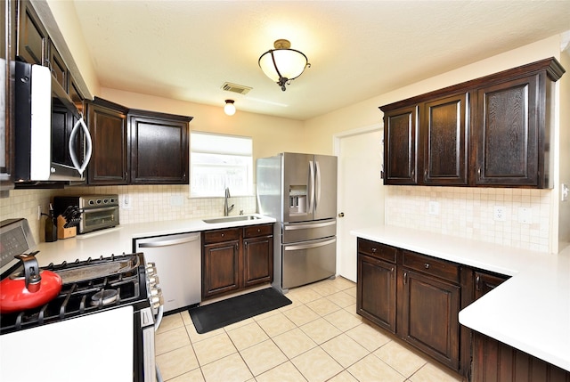 kitchen featuring light countertops, visible vents, a sink, and appliances with stainless steel finishes