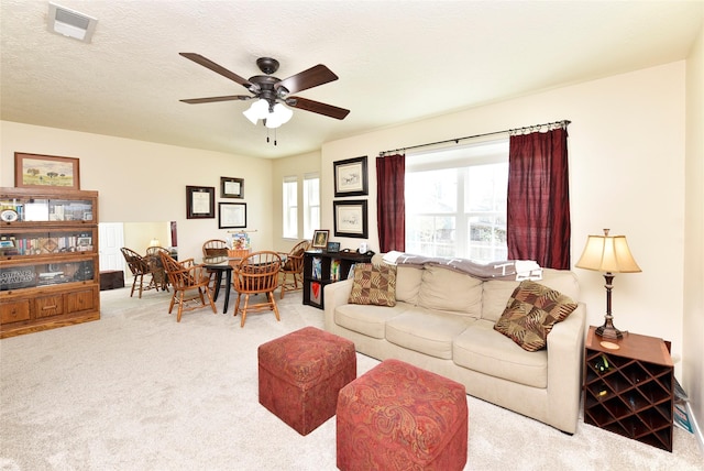carpeted living area featuring ceiling fan and visible vents