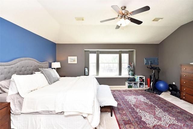 carpeted bedroom featuring lofted ceiling, a ceiling fan, and visible vents