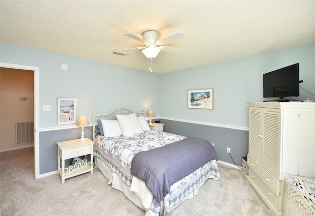 carpeted bedroom with baseboards, a ceiling fan, and visible vents