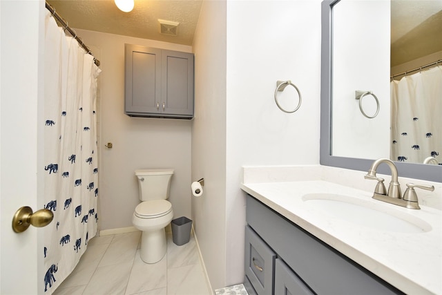 bathroom with a textured ceiling, vanity, baseboards, toilet, and visible vents