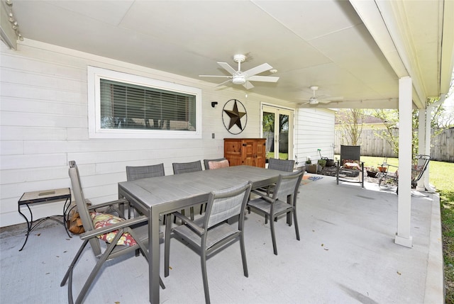 view of patio featuring outdoor dining area, fence, and ceiling fan