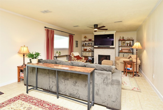 tiled living area featuring a tile fireplace, visible vents, baseboards, and ceiling fan