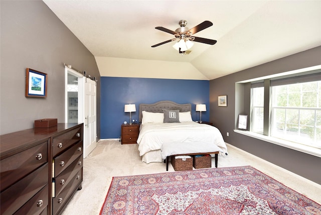 bedroom with light colored carpet, a barn door, baseboards, and vaulted ceiling