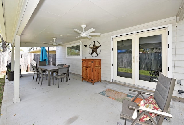 view of patio with fence, outdoor dining space, ceiling fan, and french doors