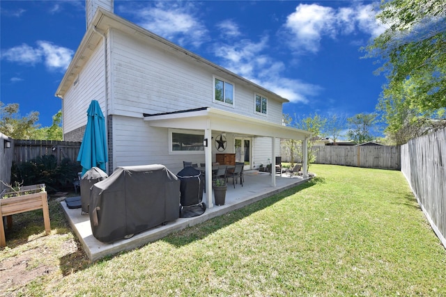 back of house with a yard, a patio area, and a fenced backyard
