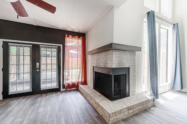3226 Poe Dr, Montgomery, TX 77356 - unfurnished living room featuring a brick fireplace, french doors, a ceiling fan, and wood finished floors