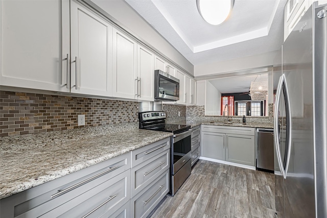 3226 Poe Dr, Montgomery, TX 77356 - kitchen with tasteful backsplash, light stone countertops, light wood-style floors, stainless steel appliances, and a sink