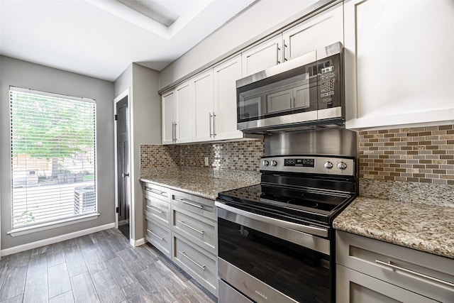 3226 Poe Dr, Montgomery, TX 77356 - kitchen featuring baseboards, light stone counters, decorative backsplash, and stainless steel appliances