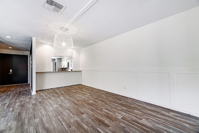3226 Poe Dr, Montgomery, TX 77356 - unfurnished living room with wood finished floors, wainscoting, visible vents, and a decorative wall
