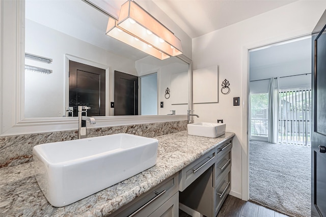 3226 Poe Dr, Montgomery, TX 77356 - full bath with double vanity, a sink, and wood finished floors