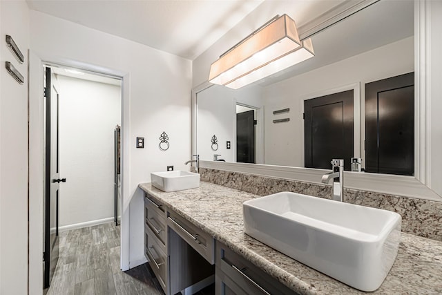 3226 Poe Dr, Montgomery, TX 77356 - bathroom with a sink, baseboards, double vanity, and wood finished floors