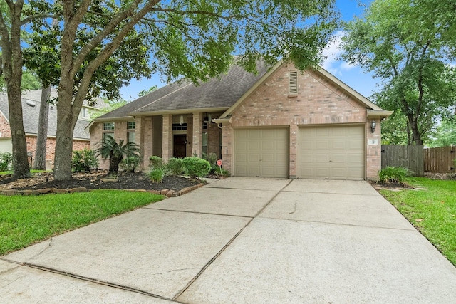 31 Trilling Bird Pl, The Woodlands, TX 77384 - view of front facade with brick siding, an attached garage, roof with shingles, and concrete driveway